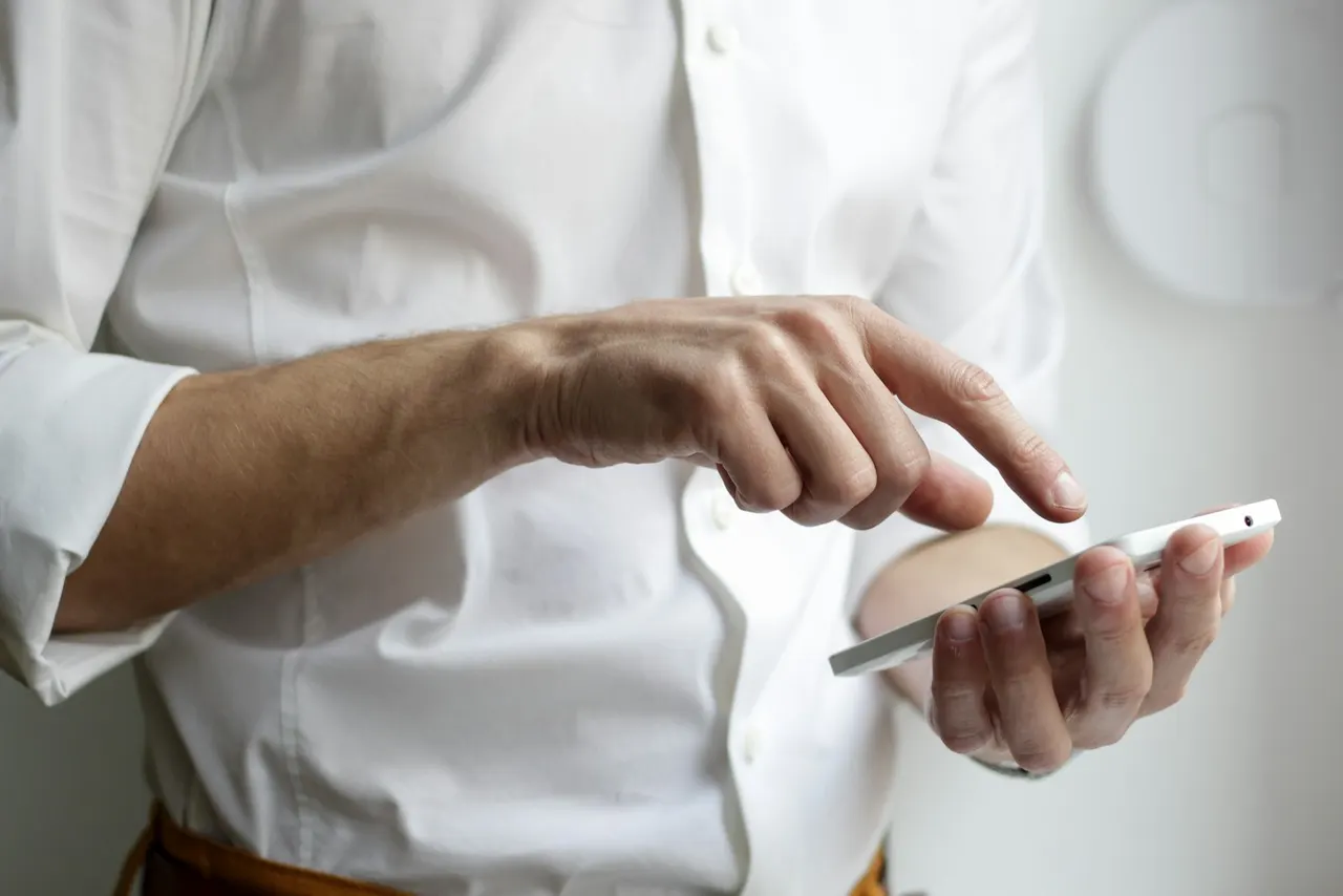 Smartphone in der Hand für den Anruf beim Schlüsseldienst